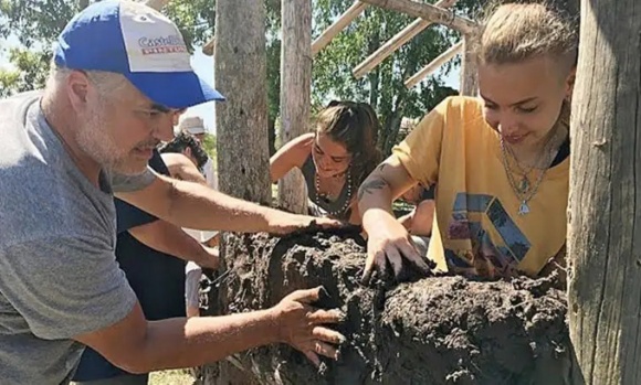 Los voluntarios de la biblioteca Palabras del Alma construyen el primer teatro de barro en el país